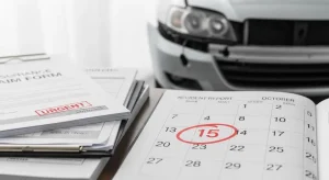 An insurance claim form with an "URGENT" stamp and a calendar with a circled date, placed in front of a damaged car, symbolizing the importance of adhering to the statute of limitations for insurance claims.